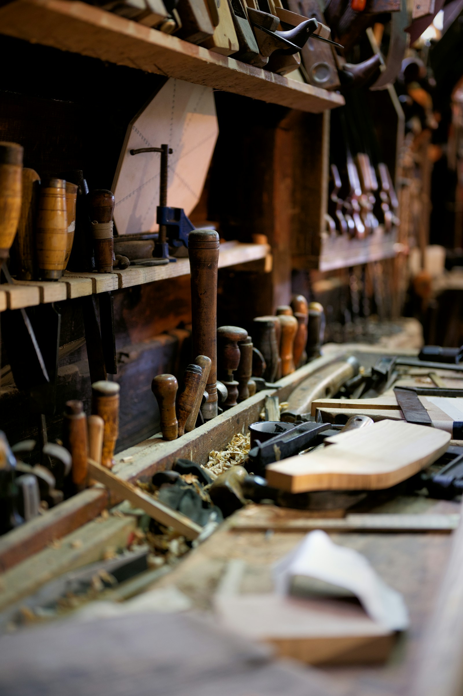 Woodworking hand tools arranged on shelves above a workbench